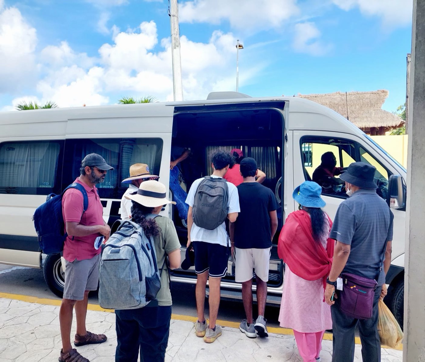 A group boarding the high-roof van at the meeting point with their day packs