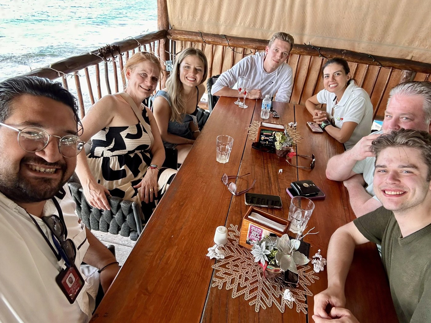 Guests and their guide over lunch by the water