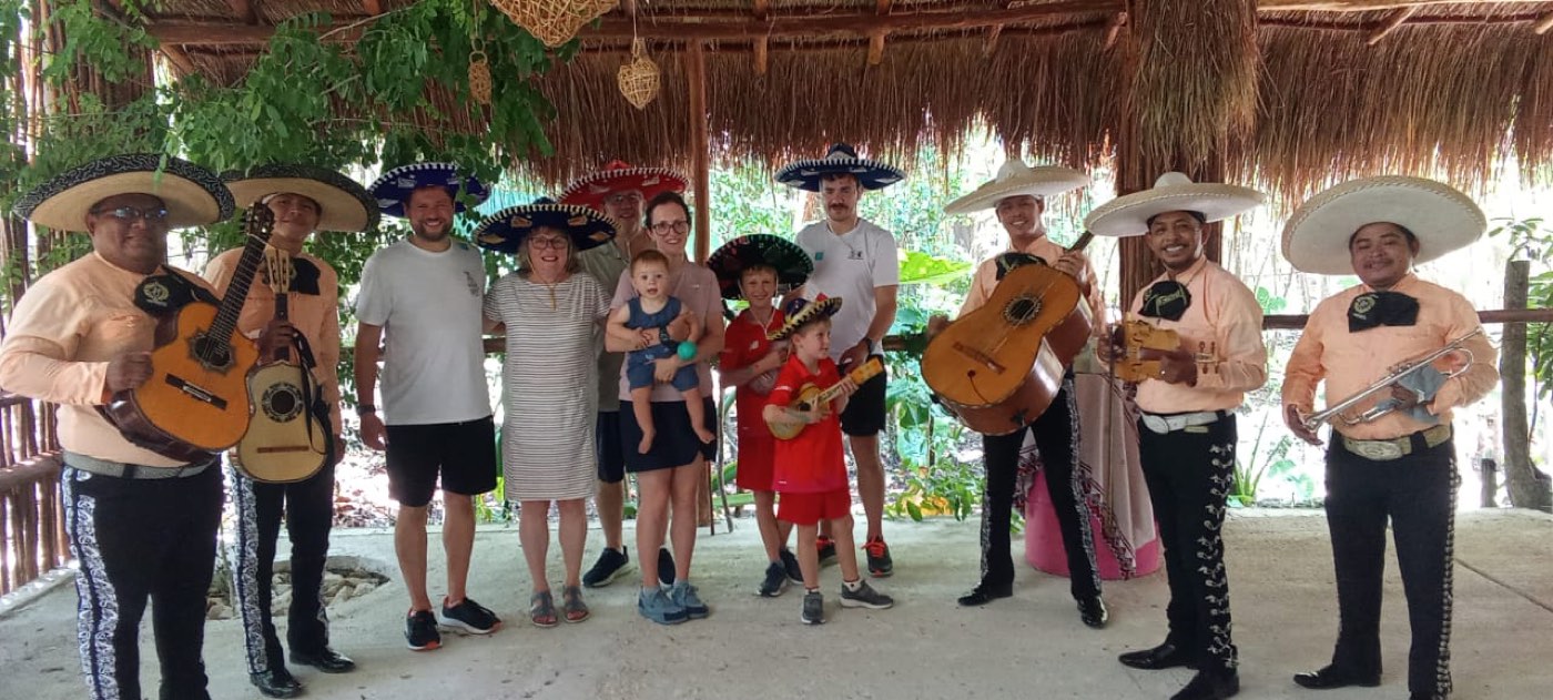 A family in sombreros surrounded by a seven-piece mariachi band