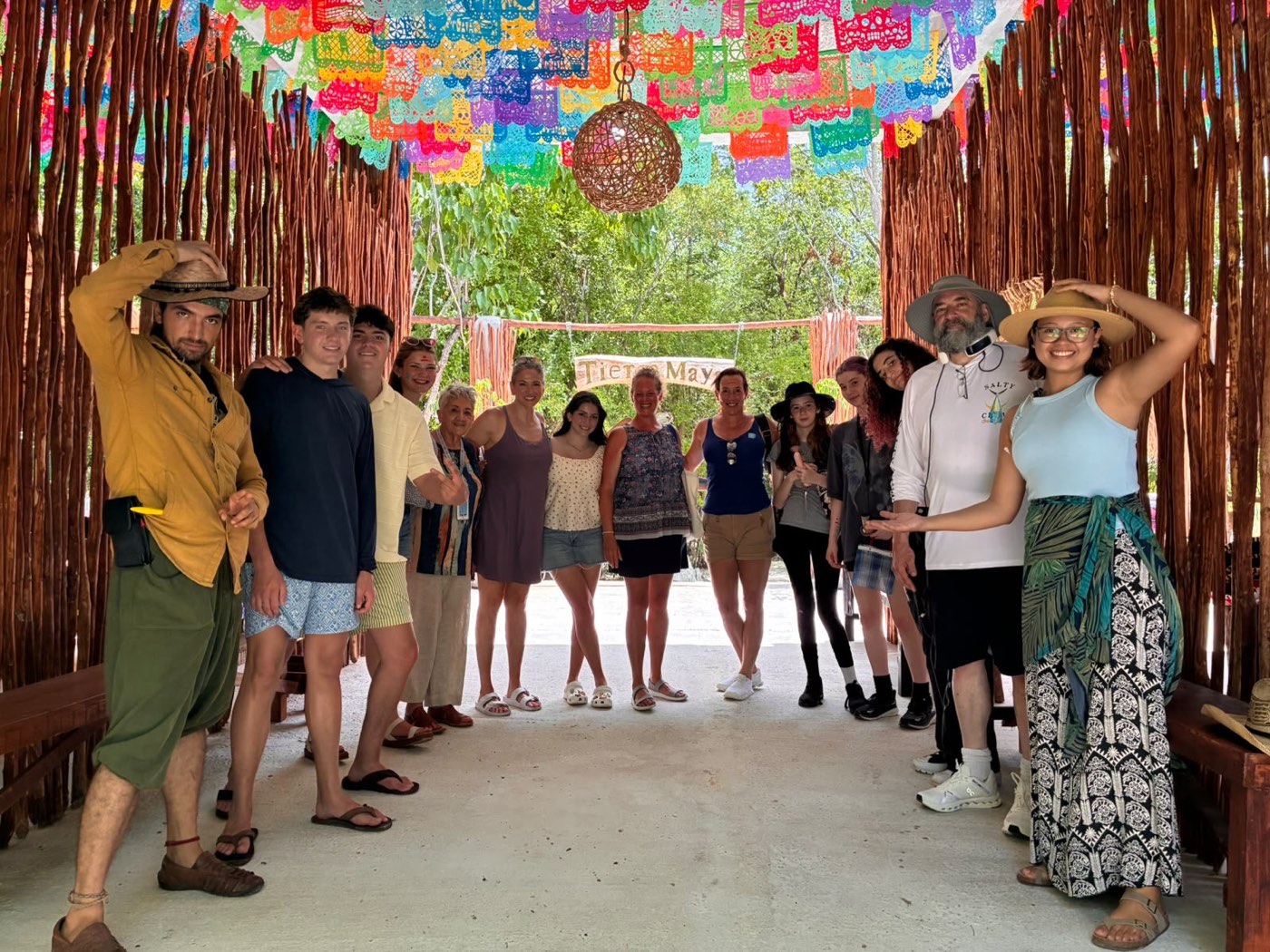 A tour group beneath a corridor of bright papel picado